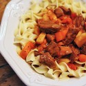 A close up photo of a bowl of Hungarian goulash and noodles.