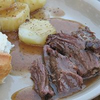 A close up photo of to die for pot roast resting on a plate.