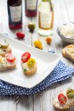 A small white plate with various appetizers.